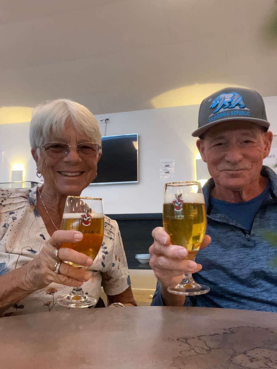 Couple toasting with beer glasses indoors at a table